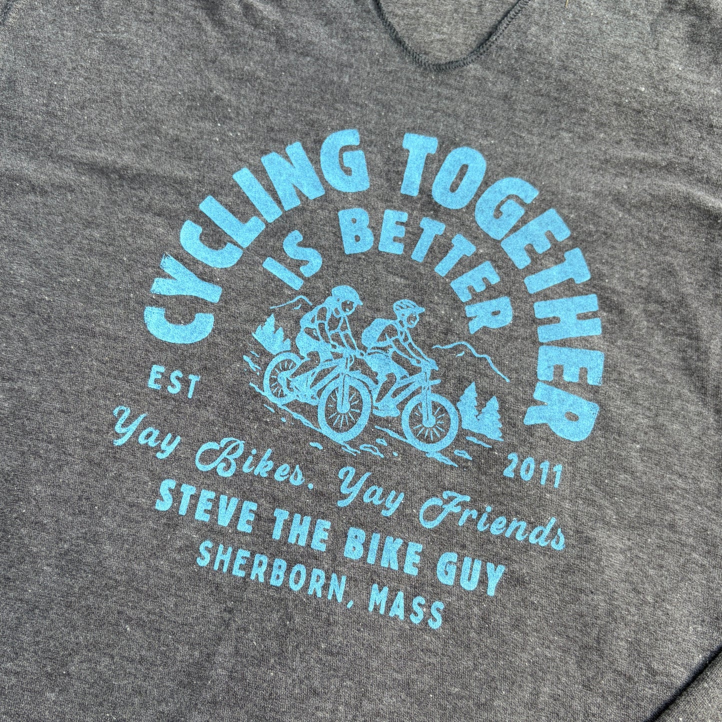 Blue imprint with two riders which says "Cycling Together is Better." Yay Bikes. yay Friends. Steve the BIke Guy